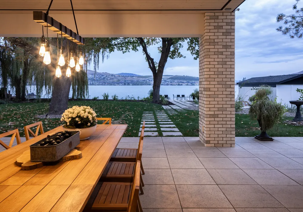 lake front home with pillar and outdoor lighting