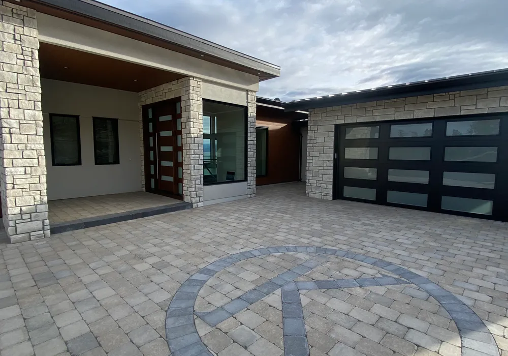 modern home with paver stone driveway