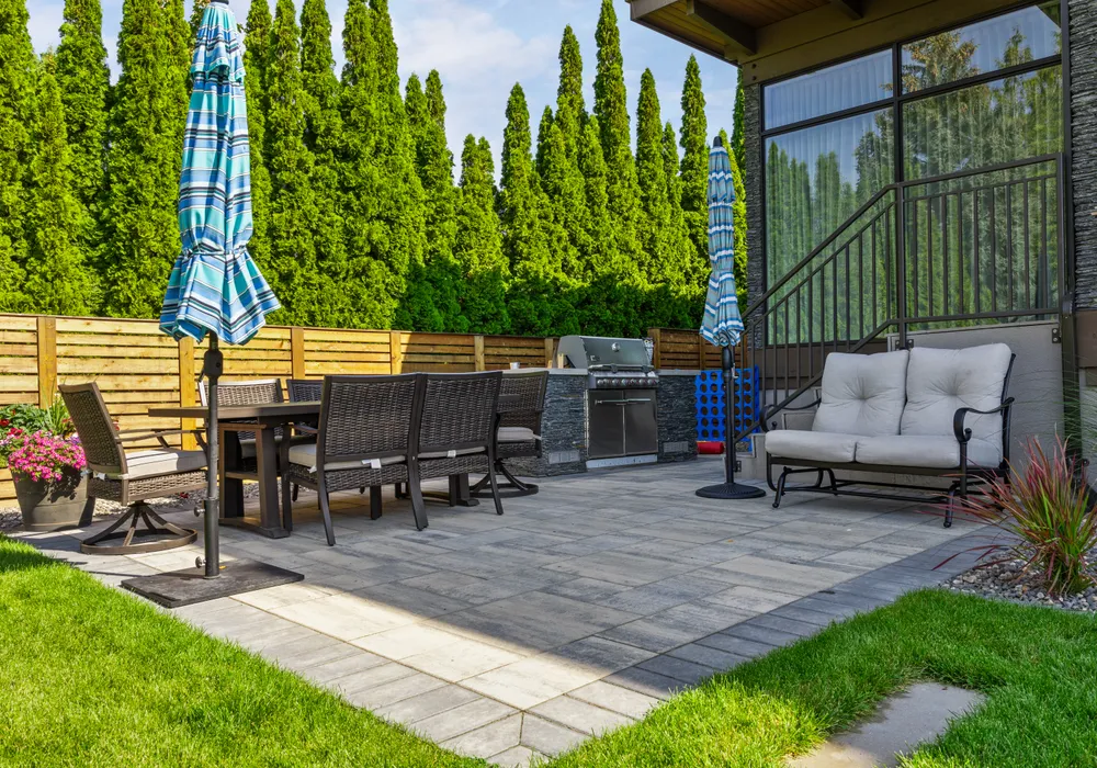 stone patio and bbq and green hedges
