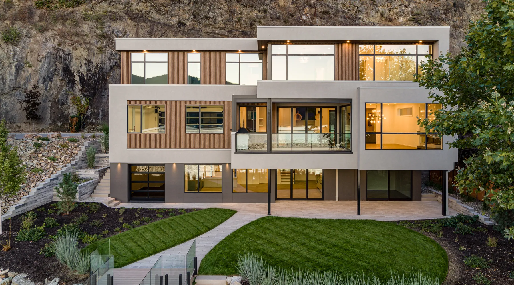 lakefront home with shrubs grasses and beautiful green yard