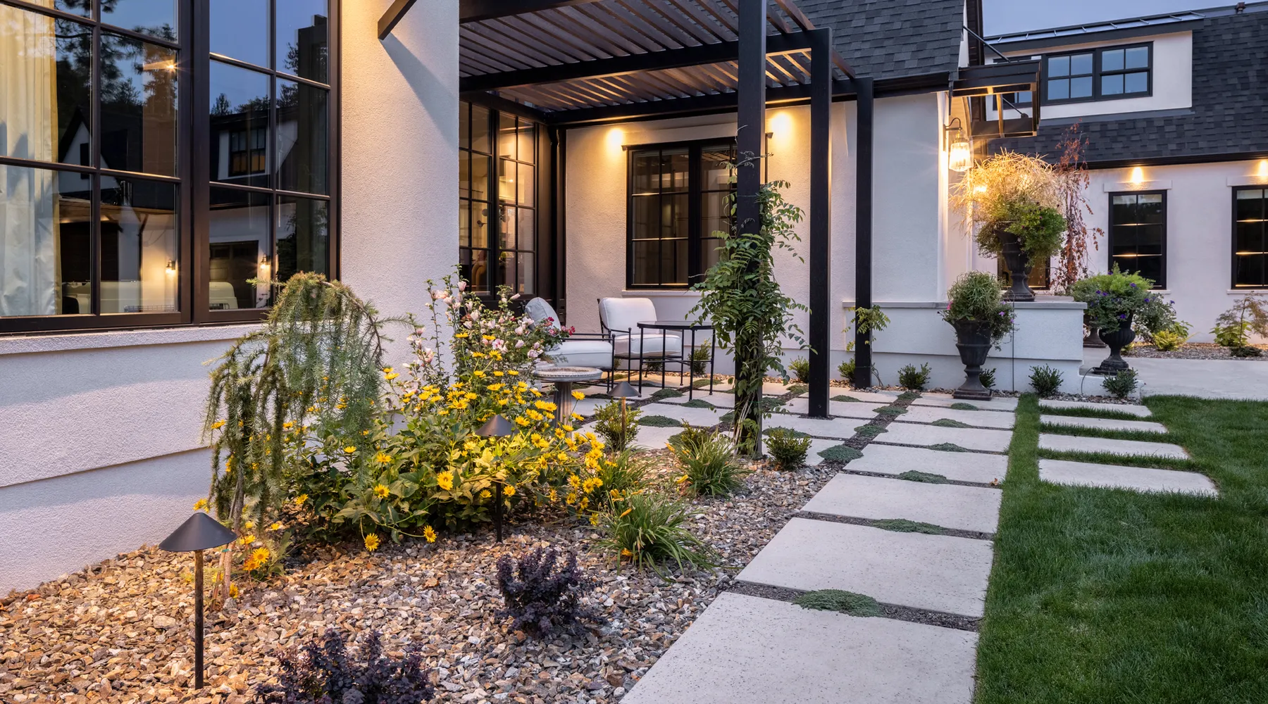 modern home lakefront with paver stone walkway and outdoor lighting